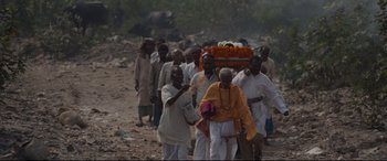 Movie still from “Lion” (2016), directed by Garth Davis – A group of people walking down a dirt road; Wide shot, High angle
