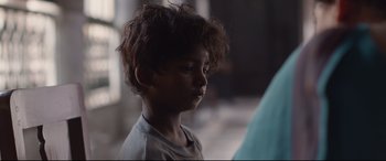 Movie still from “Lion” (2016), directed by Garth Davis – A young boy is looking into the distance; Close Up shot, Over the shoulder angle