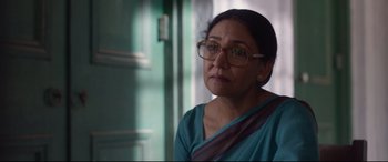 Movie still from “Lion” (2016), directed by Garth Davis – An older woman wearing glasses and a blue shirt; Close Up shot, Over the shoulder angle