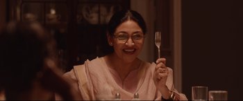 Movie still from “Lion” (2016), directed by Garth Davis – A woman holding up a fork in front of her face; Close Up shot, Over the shoulder angle