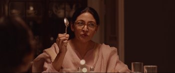 Movie still from “Lion” (2016), directed by Garth Davis – A woman holding up a spoon in front of her face; Close Up shot, Low angle