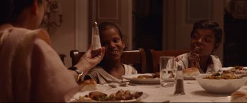 Movie still from “Lion” (2016), directed by Garth Davis – A person holding a salt and pepper shaker at a dinner table; Close Up shot, High angle