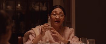 Movie still from “Lion” (2016), directed by Garth Davis – An older woman holding a glass bottle in her hand; Close Up shot, Over the shoulder angle