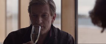 Movie still from “Lion” (2016), directed by Garth Davis – A person holding a glass of wine; Close Up shot, Over the shoulder angle