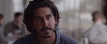 Movie still from “Lion” (2016), directed by Garth Davis – A person with a beard and mustache; Close Up shot, Over the shoulder angle