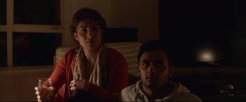 Movie still from “Lion” (2016), directed by Garth Davis – A woman and a man sitting on a couch in the dark; Medium shot, Over the shoulder angle