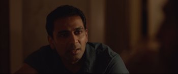 Movie still from “Lion” (2016), directed by Garth Davis – A person sitting in a room; Close Up shot, Over the shoulder angle