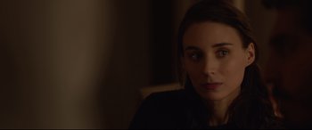 Movie still from “Lion” (2016), directed by Garth Davis – A woman sitting in a chair in a dark room; Close Up shot, Over the shoulder angle