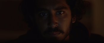 Movie still from “Lion” (2016), directed by Garth Davis – A person with a beard and mustache; Extreme Close Up shot, Low angle