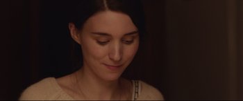 Movie still from “Lion” (2016), directed by Garth Davis – A woman's face in a dimly - lit room; Close Up shot, Over the shoulder angle