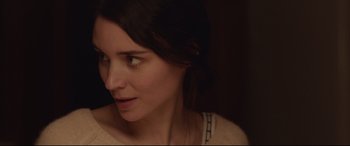 Movie still from “Lion” (2016), directed by Garth Davis – A woman's face in a dimly - lit room; Close Up shot, Over the shoulder angle