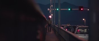 Movie still from “Lion” (2016), directed by Garth Davis – A man standing on a bridge at night with traffic lights in the background; Wide shot, Low angle