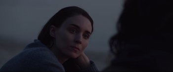 Movie still from “Lion” (2016), directed by Garth Davis – A woman sitting on top of a beach at night; Close Up shot, Over the shoulder angle