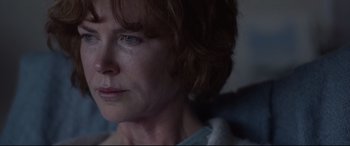 Movie still from “Lion” (2016), directed by Garth Davis – A woman's face in a dark room; Close Up shot, Over the shoulder angle