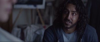 Movie still from “Lion” (2016), directed by Garth Davis – A person sitting in a room; Close Up shot, Over the shoulder angle