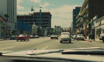 Movie still from “Lions Love (... and Lies)” (1969), directed by Agnès Varda – Cars driving down a street in a city; Extreme Wide shot, High angle