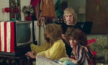 Movie still from “Lions Love (... and Lies)” (1969), directed by Agnès Varda – A group of people sitting on a couch watching television; Medium shot, High angle