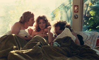 Movie still from “Lions Love (... and Lies)” (1969), directed by Agnès Varda – A group of people sitting in a bed together; Medium shot, High angle
