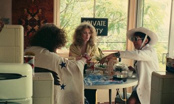 Movie still from “Lions Love (... and Lies)” (1969), directed by Agnès Varda – A group of people sitting at a table with food; Medium shot, Over the shoulder angle