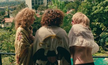 Movie still from “Lions Love (... and Lies)” (1969), directed by Agnès Varda – A group of people standing next to each other near trees; Medium shot, High angle
