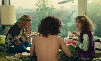 Movie still from “Lions Love (... and Lies)” (1969), directed by Agnès Varda – A group of people sitting around a table eating food; Medium shot, High angle