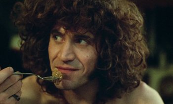 Movie still from “Lions Love (... and Lies)” (1969), directed by Agnès Varda – A person with curly hair eating something off a fork; Extreme Close Up shot, Low angle