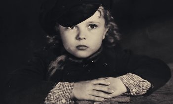 Movie still from “Lions Love (... and Lies)” (1969), directed by Agnès Varda – A little girl wearing a black hat and a plaid scarf; Close Up shot, High angle