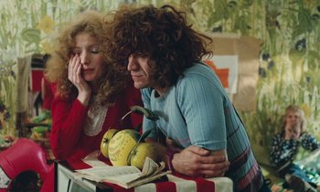 Movie still from “Lions Love (... and Lies)” (1969), directed by Agnès Varda – A man and a woman sitting next to each other at a table; Medium shot, High angle