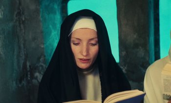 Movie still from “Lions Love (... and Lies)” (1969), directed by Agnès Varda – A woman in a nun's habit is reading a book; Close Up shot, Low angle