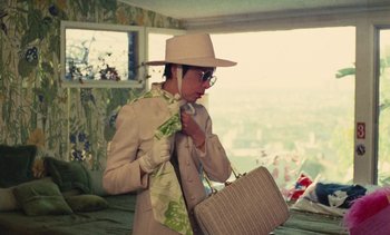 Movie still from “Lions Love (... and Lies)” (1969), directed by Agnès Varda – A woman in a hat and sunglasses holding a purse; Medium shot, High angle