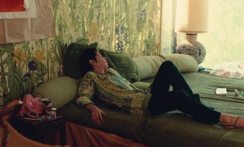 Movie still from “Lions Love (... and Lies)” (1969), directed by Agnès Varda – A person laying on a couch in a living room; Wide shot, High angle