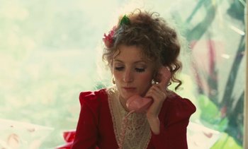 Movie still from “Lions Love (... and Lies)” (1969), directed by Agnès Varda – A woman in a red dress talking on a pink phone; Close Up shot, High angle