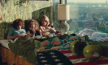 Movie still from “Lions Love (... and Lies)” (1969), directed by Agnès Varda – Two young girls sitting on a bed with a cup of tea; Wide shot, High angle