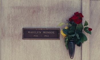 Movie still from “Lions Love (... and Lies)” (1969), directed by Agnès Varda – A grave marker with a vase of flowers next to it; Medium shot, Overhead angle