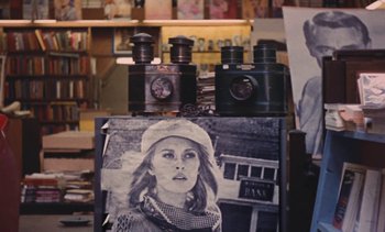 Movie still from “Lions Love (... and Lies)” (1969), directed by Agnès Varda – An old photo of a woman and some old cameras; Extreme Close Up shot, High angle