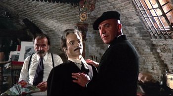 Movie still from “Lisa and the Devil” (1973), directed by Mario Bava – A man in a black suit and a man in a black hat; Medium shot, Low angle