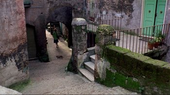Movie still from “Lisa and the Devil” (1973), directed by Mario Bava – An elephant is walking down a path near a building; Extreme Wide shot, High angle