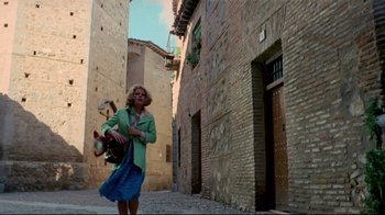 Movie still from “Lisa and the Devil” (1973), directed by Mario Bava – A woman walking down a street holding a bag; Extreme Wide shot, Low angle