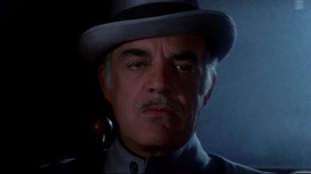 Movie still from “Lisa and the Devil” (1973), directed by Mario Bava – An older man wearing a hat and a pipe in his mouth; Close Up shot, Low angle