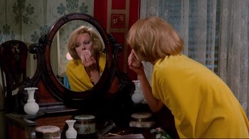 Movie still from “Lisa and the Devil” (1973), directed by Mario Bava – A woman looking in the mirror while brushing her teeth; Medium shot, High angle