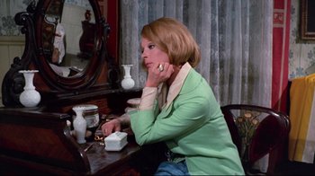 Movie still from “Lisa and the Devil” (1973), directed by Mario Bava – A woman sitting in front of a mirror at a desk; Medium shot, High angle