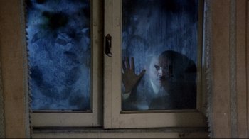 Movie still from “Lisa and the Devil” (1973), directed by Mario Bava – A child is looking out a window at night; Medium shot, High angle