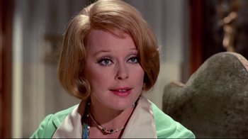 Movie still from “Lisa and the Devil” (1973), directed by Mario Bava – An older woman wearing a green shirt and a white scarf; Close Up shot, Over the shoulder angle