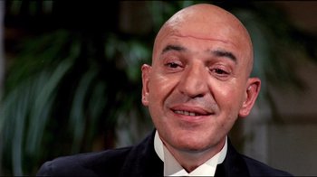 Movie still from “Lisa and the Devil” (1973), directed by Mario Bava – A bald man in a suit and white shirt; Close Up shot, Low angle