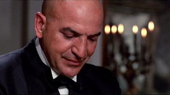 Movie still from “Lisa and the Devil” (1973), directed by Mario Bava – A bald man in a black tuxedo looking down; Close Up shot, Low angle