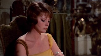 Movie still from “Lisa and the Devil” (1973), directed by Mario Bava – A person sitting in a chair holding a cell phone; Close Up shot, Low angle