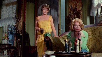 Movie still from “Lisa and the Devil” (1973), directed by Mario Bava – A woman standing in front of a mirror in a yellow dress; Medium shot, Low angle