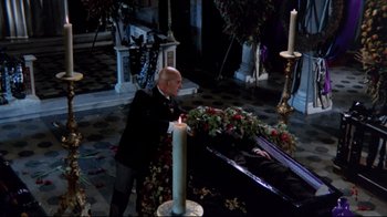 Movie still from “Lisa and the Devil” (1973), directed by Mario Bava – A man lighting a candle next to a man laying on the ground; Wide shot, High angle