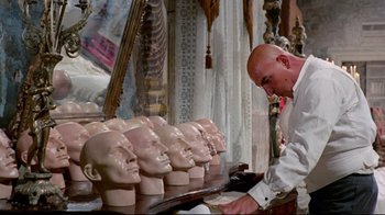 Movie still from “Lisa and the Devil” (1973), directed by Mario Bava – A man is looking at a row of bald heads; Close Up shot, Over the shoulder angle