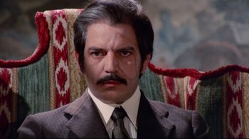 Movie still from “Lisa and the Devil” (1973), directed by Mario Bava – A person wearing a suit and tie; Close Up shot, High angle